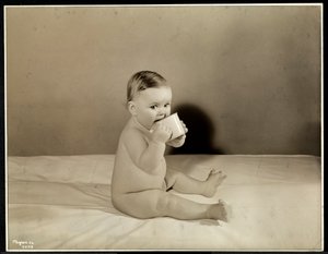 Vauva istuu sängyssä ja juo kupista Maternity Center Associationissa osoitteessa 70th Street East River, New York, 1935 (hopeagelatiiniprintti)